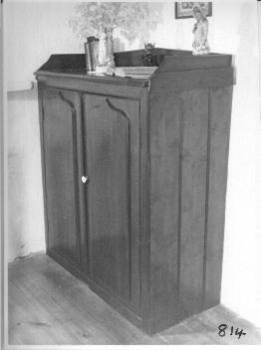 Cedar chiffonier with raised backboards on three sides. Two doors with raised fronts as decoration. Pine sides. White knob on door.
