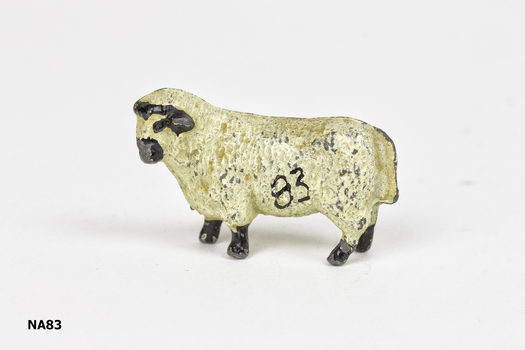 Metal cream painted sheep with black feet, black horns and nose.