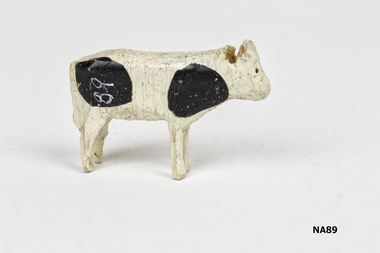White painted cow with four black feet.