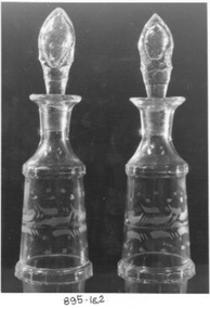 Two glass bottles with glass stoppers. Leaf pattern etched in glass. Used for vinegar and oil at the table
