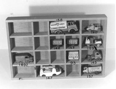 Unpainted wooden block in shape of house. 