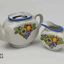 Child's china tea set - white with blue edge and flowered pattern. Comprising: tea pot with lid, milk jug with one handle, 1 cup, 1 bowl, 1 oval plate, 1 oval plate, 3 saucers, 5 plates.