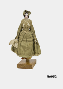 Old doll - china hands, feet, remainder wood.  Dressed in green dress and bonnet