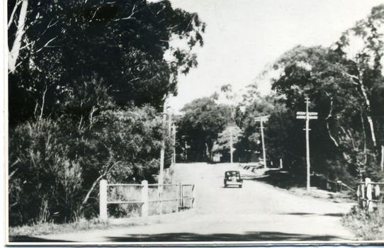 B/W photo mounted on board depicting bridge at Blackburn Road with car in picture.