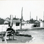 Black and white photo of Mitcham Railway Station 1945. In the foreground, man sitting on bench.