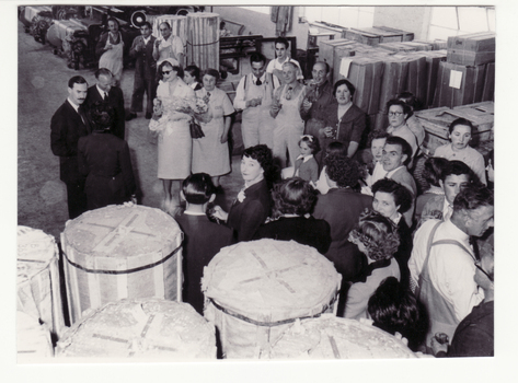 Black and white photo of Mr. Roger de Stoop and Prince and Princess of Luxembourg with workers in factory