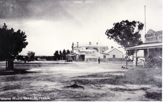 Black and white photo of the northern  cnr Whitehorse and Mitcham Roads, Mitcham, showing Hughs Produce Store, with his white horse and delivery wagon outside.