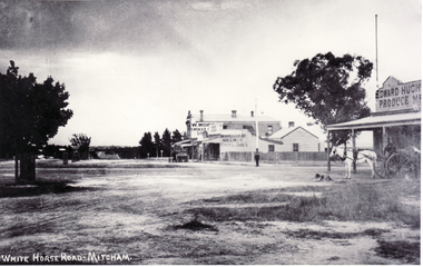Black and white photo of the northern  cnr Whitehorse and Mitcham Roads, Mitcham, showing Hughs Produce Store, with his white horse and delivery wagon outside.