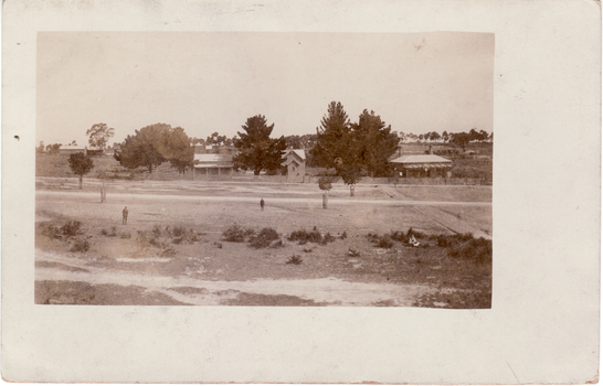 Black and white photo of L - R : Mitcham Railway Station (at rear)|Teacher's Residence, St.John's Catholic Church|and Mitcham's First Police Station..(The 'great three chain road' in the foreground  is now Maroondah  Highway -