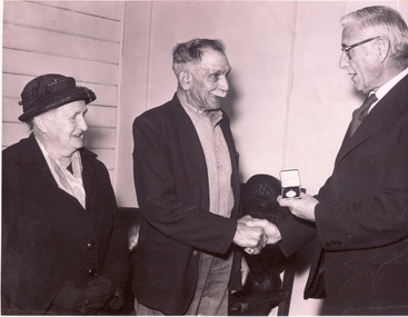 Photo of Presentation of a silver medal by Mr. Don Walker to Mr. Harry Alderton for 50 years service to Australian Tesselated Tile Company.   Mrs Alderton is also in the picture.