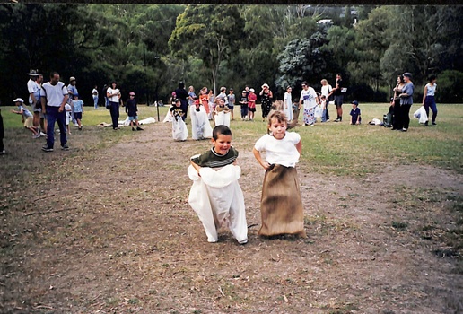 Coloured photo of Children taking part in Sack Race .
