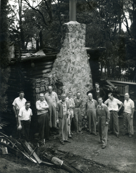 Toc H members of Mitcham Branch outside burnt remains of log cabin off Agra Street, Mitcham in March 1960