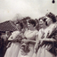 Joyce Suto in bridesmaids dress of gold nylon with olive green sash, worn at wedding in Gloucestshire, England on 8th April 1947. 