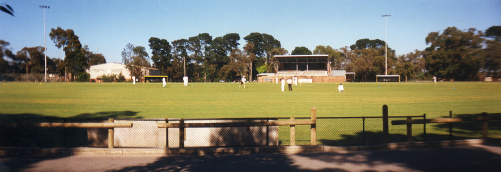 Walker Park, Whitehorse Road, Mitcham showing Cricket match in progress with the grandstand in background. 