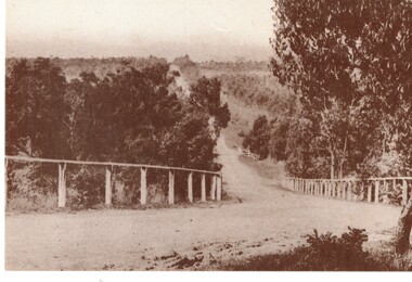 Black and white historic postcard (Set 2 No 5 ) Boronia Road, Vermont approaching Dandenong Creek, Vermont in the 1920s. 