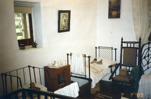 Coloured photograph of interior of children's room in Schwerkolt Cottage.