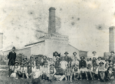  Australian Brick and Tile Company building, with their staff in foreground, some holding tiles.