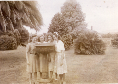 E.E. Walkers' garden; four young women near garden urn