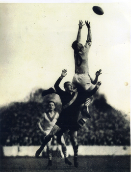 Bob Pratt taking a mark over opposition play. One team mate in background