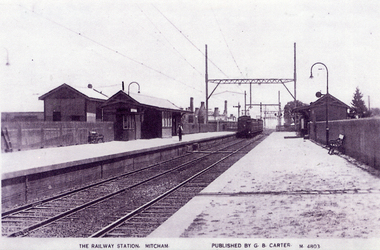 Mitcham Railway Station with an electric train leaving the station for Melbourne. english