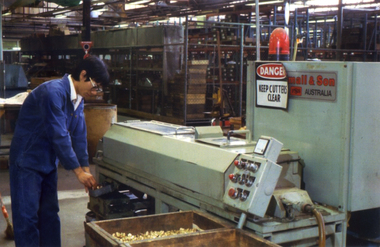 Male worker in a blue boiler suit in a Stanley Works machine room.