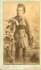Young dark haired female child wearing a pleated suit with short skirt and cummerbund,