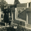 Woman in a dark dress standing next to a tombstone 