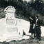 Man and woman in war cemetery looking at headstone , dated 1944. 