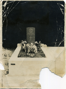  Grave and tombstone against a dark background.