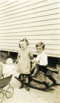 Alwyn & Alison Till in front of weatherboard building. 