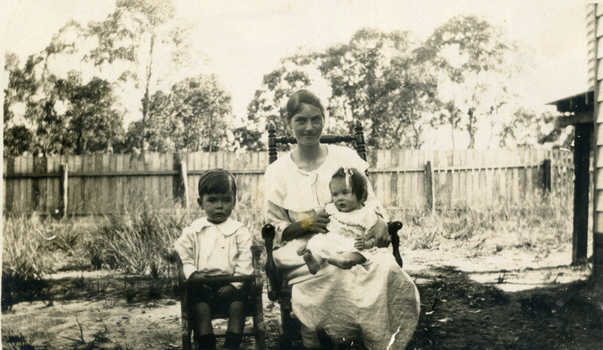 Evelyn Till sitting in chair with Alison on her knee. 