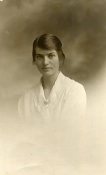 Studio postcard photograph of Evelyn Maggs in a white dress. Dated 1919.