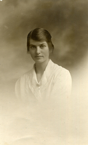 Studio postcard photograph of Evelyn Maggs in a white dress. Dated 1919.