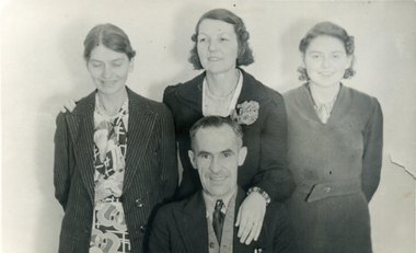 Three women standing behind one man..