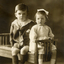 Alwyn and Alison Till on a wooden piano stool Inscription