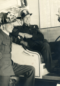 Alwyn Till and Tom Mildred in airforce uniform wearing fireman's helmets. 