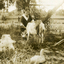 Woman with a goat and a duck in a farm setting. 