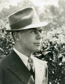 Alwyn Till wearing a suit, tie and hat.