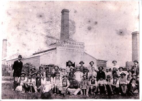 Photograph of a group of men in front of the Australian Tesselated Tile building. 