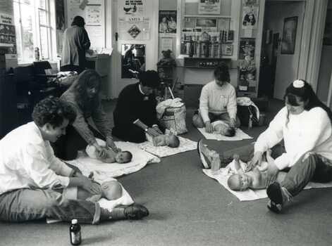 Photograph taken in the Mitcham Maternal and Child Care Centre of a group of five women learning the art of baby massag