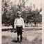 Black & white photograph of Cedric Lowen in the family orchard about 1920