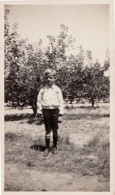 Black & white photograph of Cedric Lowen in the family orchard about 1920