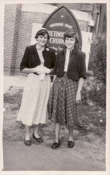 Black and white photograph of two young women standing in front of the Warrigal Road Methodist Church about 1954. .