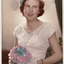 Gloria Mullins as a debutante in 1964.  She is carrying a posy of pink and blue flowers which are replicated in her hair