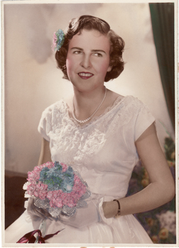 Gloria Mullins as a debutante in 1964.  She is carrying a posy of pink and blue flowers which are replicated in her hair