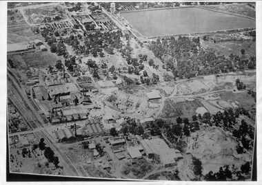 Black and white aerial photograph of Mitcham showing the reservoir, Australian Tesselated Tiles with the clay pit at the rear, and Monarch Tiles (1914-16) in the foreground.