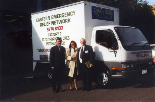 Jim Jamieson, an unknown woman and Keith Rooney in front of a truck that was donated to the Whitehorse Emergency Relief Network by Mitcham Rotary and Jack Brockhoff of Brockhoff Biscuits.