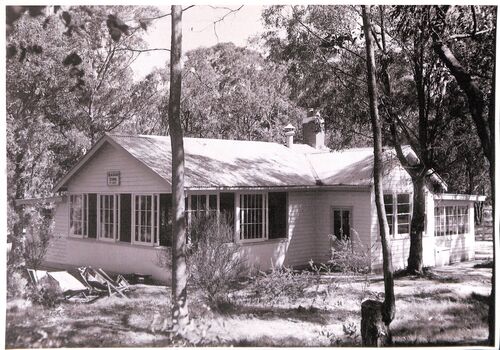 Black and white photograph of the Open Air School, Blackburn showing the building in a bush setting with deck chairs on the left.