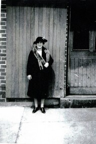 Black and white photograph of Mary Helen Davin in front of the door to the dairy. 
