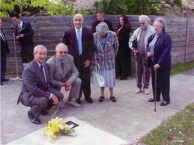 Coloured photo copy of nine people at the laying of a wreath